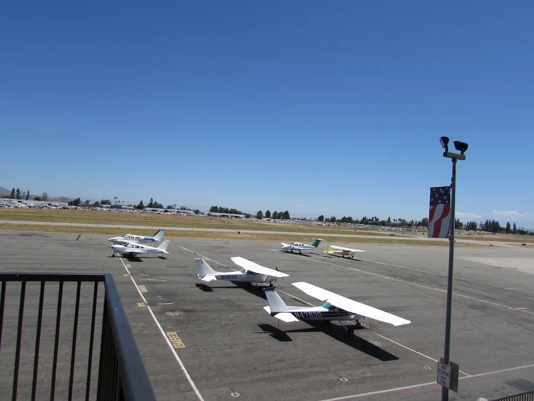 Cessna training aircraft lined up on the ramp at Riverside Municipal Airport (KRAL) at sunrise