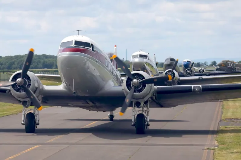 Restored Douglas DC-3 warbirds taxiing at a Veterans Day commemorative fly-in